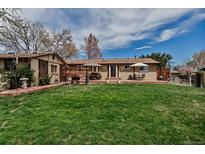 Spacious backyard with a well-maintained lawn, patio, and lush greenery at 3630 W Saratoga Ave, Littleton, CO 80123