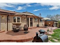 Brick patio area with outdoor seating, tables, and umbrellas, great for entertaining and enjoying the outdoors at 3630 W Saratoga Ave, Littleton, CO 80123
