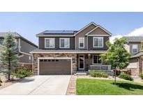 Two-story home with stone accents, solar panels, neutral siding, landscaped yard and a two car garage at 7243 S Old Hammer Ct, Aurora, CO 80016