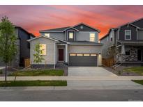 Charming two-story home showcasing a gray brick facade, attached two-car garage, and a well-manicured lawn at 547 Homestead Ave, Brighton, CO 80601
