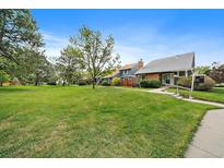 Charming home featuring a well-manicured front lawn and lush green trees at 8699 Garrison Ct, Arvada, CO 80005