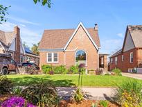 Charming brick home with manicured lawn and beautiful landscaping at 1528 Holly St, Denver, CO 80220