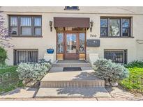 Inviting front entrance with a covered porch, diamond pane windows, and meticulously maintained landscaping at 700 E Ellsworth Ave # 2, Denver, CO 80209
