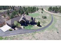 An aerial view showcases this beautiful single-Gathering home and its well-manicured lot and long driveway at 12984 Crowfoot Springs Rd, Larkspur, CO 80118