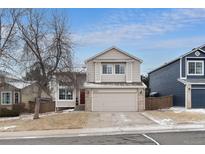 Two story home featuring a two car garage, red front door, and manicured front yard at 9676 Whitecliff Pl, Highlands Ranch, CO 80129