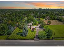 Expansive property with manicured lawn, mature trees, and a sprawling home under a beautiful sunset at 4600 S University Blvd, Englewood, CO 80113