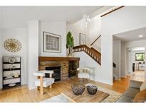 Bright living room with a brick fireplace, hardwood floors, and modern furnishings at 9400 E Iliff Ave # 292, Denver, CO 80231