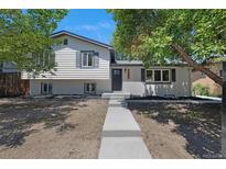 Charming two-story home featuring a well-manicured lawn, a gray door, and a concrete pathway leading to the entrance at 11877 Keough Dr, Northglenn, CO 80233