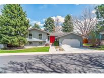 Charming two-story home with blue paint, bright red front door, and well-manicured lawn at 3722 S Quebec St, Denver, CO 80237