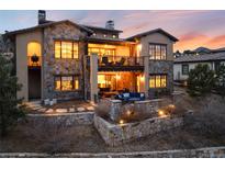 Stunning two-story home featuring stone accents, a balcony, and an outdoor living space at 8310 Raphael Ln, Littleton, CO 80125