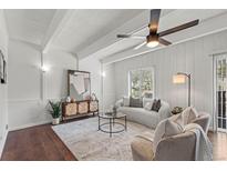 Bright living room featuring a modern sofa, accent chairs, ceiling fan, and stylish decor at 9725 E Harvard Ave # 323, Denver, CO 80231