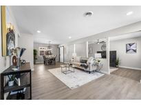 Bright living room with hardwood floors, modern fireplace, and large windows at 914 Quari Ct, Aurora, CO 80011