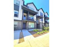 Modern townhouse with a black and white exterior, a small yard, and a front porch at 12336 W 52Nd Ave, Wheat Ridge, CO 80033