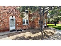 Charming brick townhouse featuring a white front door and meticulously maintained landscaping at 3616 W Radcliff Ave, Denver, CO 80236