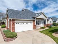 Charming home with a well-maintained front yard, brick accents, and a two-car garage at 3205 E 102Nd Pl, Thornton, CO 80229