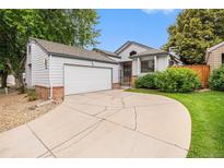 Charming home exterior with a well-maintained lawn, and a two-car garage at 11196 E Baltic Dr, Aurora, CO 80014
