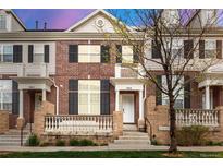 Charming brick townhome featuring a cozy front porch and well-maintained landscaping at 3818 S Dallas St, Aurora, CO 80014