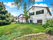 Charming two-story home with a well-maintained lawn and mature trees, showcasing its inviting facade at 431 N Harlan St, Lakewood, CO 80226