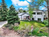 Charming two-story home with a well-maintained lawn, mature trees, and an inviting covered porch at 431 N Harlan St, Lakewood, CO 80226