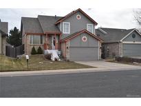 Charming gray two-story home featuring a well-manicured front yard and attached two-car garage at 486 W 116Th Pl, Northglenn, CO 80234