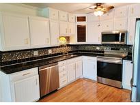 Updated kitchen features white cabinets, stainless steel appliances, and sleek black countertops at 715 S Alton Way # 10A, Denver, CO 80247