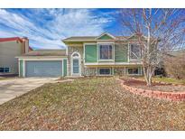 Green two-story house with stone accents and a gray garage door at 5737 S Odessa St, Centennial, CO 80015