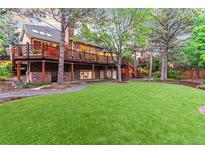 Expansive backyard featuring well-maintained lawn and a wooden deck with a cozy outdoor living space at 16416 E Powers Pl, Centennial, CO 80015