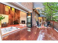 Inviting outdoor deck featuring a hot tub, fireplace, spiral staircase, and outdoor seating area at 16416 E Powers Pl, Centennial, CO 80015