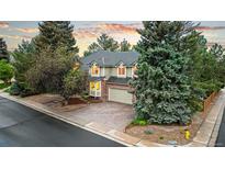 Charming two-story home features a brick facade, lush landscaping, and an attached two-car garage at 16416 E Powers Pl, Centennial, CO 80015