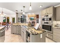 Bright kitchen featuring granite countertops, stainless steel appliances, and an open floor plan at 16416 E Powers Pl, Centennial, CO 80015