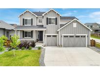 Charming two-story home featuring a covered porch, well-maintained lawn, and a spacious two-car garage at 10968 Lewiston St, Commerce City, CO 80022