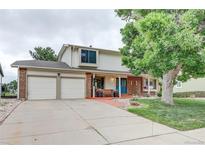 Charming two-story home with a two-car garage, mature landscaping, and a welcoming front porch at 10137 W Berry Dr, Littleton, CO 80127