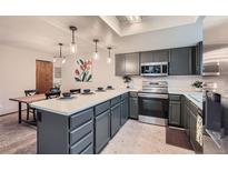 Well-lit kitchen with modern appliances, countertops, and pendant lighting at 9556 W 89Th Cir, Broomfield, CO 80021
