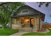 Charming brick home with a covered front porch and green lawn at 1172 Harrison St, Denver, CO 80206