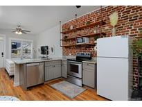 Open kitchen with stainless steel appliances, gray cabinets, and breakfast bar with seating at 2424 N Clay St, Denver, CO 80211