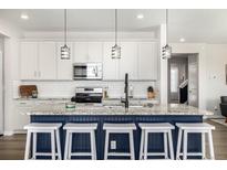 Bright kitchen features a large island, granite countertops, modern lighting, and stainless steel appliances at 23652 E 40Th Ave, Aurora, CO 80019