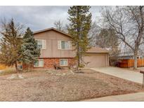 Split level home with attached two-car garage and xeriscaped front yard at 909 E 7Th Ave, Broomfield, CO 80020