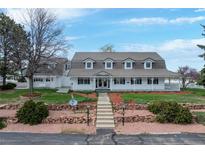 Charming two-story home featuring a well-manicured front lawn, complemented by a classic white picket fence and inviting walkway at 6231 Prospect Rd, Longmont, CO 80503