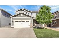 Charming two-story home with a well-manicured lawn, large tree, and attached two-car garage at 7888 Tejon St, Denver, CO 80221