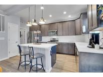 Modern kitchen features stainless steel appliances, gray cabinets, a center island, and stylish pendant lighting at 7888 Tejon St, Denver, CO 80221