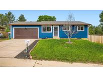 Charming single-story home with blue stucco exterior, brown garage door, and well-maintained front yard at 18662 E Brown Pl, Aurora, CO 80013