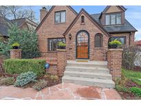 Charming brick home with a beautiful arched front door and well-maintained landscaping at 371 Birch St, Denver, CO 80220