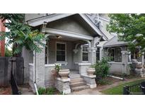 Charming brick front porch with decorative pillars and ornate flower pots, offering a cozy and inviting entryway at 1266 N Pearl St, Denver, CO 80203