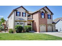 Beautiful two-story home featuring a brick facade and well-manicured lawn at 11951 Singing Winds St, Parker, CO 80138