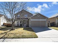 Charming two-story home featuring a well-maintained lawn, two-car garage, and traditional architecture at 12196 Grape St, Thornton, CO 80241