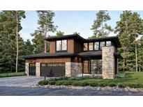 Striking modern home featuring a stone accent wall, sleek black trim, two-car garage, and wood siding amongst mature trees at 945 Saint Andrews Ln, Louisville, CO 80027