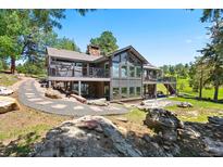 Modern two-story home with large windows and balconies overlooking a beautifully landscaped yard at 1555 Genesee Ridge Rd, Golden, CO 80401