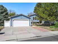 Charming two-story home with blue siding, attached two-car garage, well-maintained lawn, and brick walkway at 8679 Apache Plume Dr, Parker, CO 80134