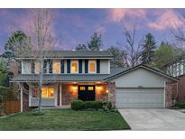 Charming two-story home featuring brick and gray siding with a well-manicured front lawn and lush landscaping at 8132 Lodgepole Trl, Lone Tree, CO 80124