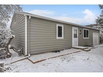 Charming single-story home featuring neutral siding, white trim, and a well-maintained front yard, partially covered in snow at 10763 Lewis Cir, Broomfield, CO 80021